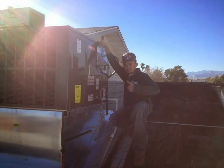 HVAC technician performing AC Tune-Up on a rooftop unit in Odessa