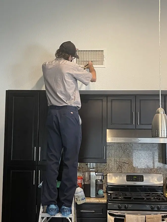 Technician inspecting an air vent during HVAC service in Odessa